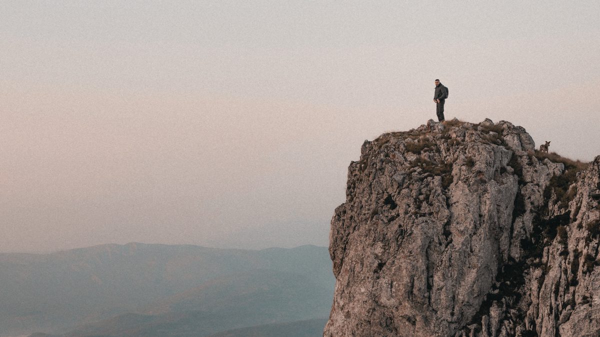 A lone climber on a mountain face — the founder navigating the route ahead